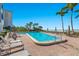 Beautiful pool and beach at beachfront condo with palm trees and lounge chairs on brick paver deck on sunny day at 1102 Benjamin Franklin Dr # 409, Sarasota, FL 34236