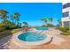 A luxurious pool and hot tub with brick patio, palm trees, and seating for residents to enjoy at 1102 Benjamin Franklin Dr # 409, Sarasota, FL 34236