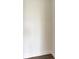 Empty closet with white walls and dark brown wood-look floors at 111 Golden Gate Pt # 402, Sarasota, FL 34236