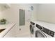 Laundry room with modern washer and dryer at 111 Golden Gate Pt # 402, Sarasota, FL 34236