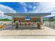 Covered outdoor kitchen with grill and bar seating at 111 Golden Gate Pt # 402, Sarasota, FL 34236