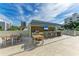 Outdoor kitchen with grill, bar seating, and TV at 111 Golden Gate Pt # 402, Sarasota, FL 34236