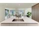 Kitchen island with sink overlooking living room at 111 Golden Gate Pt # 402, Sarasota, FL 34236
