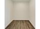 Empty room with dark brown wood-look floors and white walls at 111 Golden Gate Pt # 402, Sarasota, FL 34236
