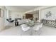 Open concept dining area with glass table and modern chairs, kitchen view at 111 Golden Gate Pt # 402, Sarasota, FL 34236