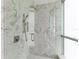 Modern shower with marble tile and glass door, bright and spacious at 111 Golden Gate Pt # 402, Sarasota, FL 34236