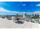 Relaxing rooftop terrace with seating, tables, and stunning water views at 111 Golden Gate Pt # 402, Sarasota, FL 34236