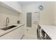 Bright laundry room with modern washer and dryer at 111 Golden Gate Pt # 402, Sarasota, FL 34236