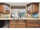 A kitchen sink, surrounded by granite countertops, rich wooden cabinets, and natural light at 117 Hillcrest Dr, Bradenton, FL 34209