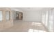 Bright living room featuring light wood flooring and natural light streaming through the shuttered windows at 117 Hillcrest Dr, Bradenton, FL 34209