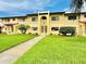Front view of condo building showcasing its architecture and lawn at 1446 56Th W St # 1446, Bradenton, FL 34209