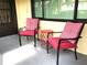 Small patio with two red chairs and a small side table at 1446 56Th W St # 1446, Bradenton, FL 34209
