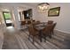 Elegant dining room with a glass table, brown leather chairs, and modern chandelier at 1508 Pelican Cove Rd # Gr233, Sarasota, FL 34231