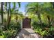 Private gated entrance with lush landscaping and a brick pathway at 1610 Hudson Pointe Dr, Sarasota, FL 34236