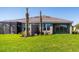 Expansive backyard with healthy lawn, mature palm trees, and an enclosed patio area at 16112 Isola Pl, Bradenton, FL 34211