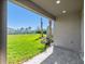 Covered patio overlooks a spacious backyard with lush green lawn and young palm trees at 16112 Isola Pl, Bradenton, FL 34211