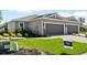 Charming home exterior with manicured landscaping, gray three-car garage, and a tile roof at 16112 Isola Pl, Bradenton, FL 34211