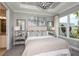 Spacious main bedroom with large windows, plush bedding, and an elegant chandelier at 16112 Isola Pl, Bradenton, FL 34211