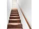 Carpeted staircase with wood handrail leading to upper level at 1742 Adams S Cir, Largo, FL 33771