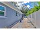Brick walkway beside the house with gravel and a fence at 2110 Hawthorne St, Sarasota, FL 34239