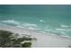 Aerial view of a pristine beach with calm waves and clear water at 3820 Ironwood Ln # 106-I, Bradenton, FL 34209