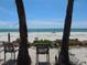 Relaxing beach view from between palm trees with white sand and ocean at 3820 Ironwood Ln # 106-I, Bradenton, FL 34209