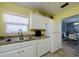 Modern kitchen with white cabinets, stainless steel appliances, and a dining area view at 6079 Coral Way, Bradenton, FL 34207