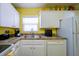 Updated kitchen with white cabinets, double sink, and modern appliances at 6079 Coral Way, Bradenton, FL 34207