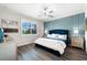 Main bedroom with blue velvet headboard, wood floors, and a walk-in closet at 6546 Rosehill Farm Run, Lakewood Ranch, FL 34211