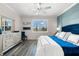 Main bedroom featuring a blue bed, dresser, and large window with plantation shutters at 6546 Rosehill Farm Run, Lakewood Ranch, FL 34211