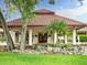 Spanish-style clubhouse with tile roof and lush landscaping at 8047 Desoto Woods Dr, Sarasota, FL 34243