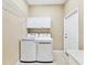 Laundry room with washer, dryer, and overhead cabinets at 8047 Desoto Woods Dr, Sarasota, FL 34243