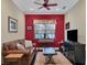 Home office with a red accent wall, leather sofa, and built-in entertainment center at 11414 Hawick Pl, Lakewood Ranch, FL 34202