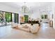 Open living space with a large green sofa and a stylish chandelier at 1331 Quail Dr, Sarasota, FL 34231