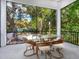 Screened porch with glass-top dining table and wicker chairs at 1331 Quail Dr, Sarasota, FL 34231