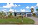 Ranch home with updated landscaping and a dark garage door at 138 Paddington Rd, Venice, FL 34293