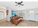 Living room with brown leather sofa and ceiling fan at 138 Paddington Rd, Venice, FL 34293