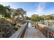 Walkway leading to boat docks on the water, surrounded by mature trees and lush greenery at 1519 Pelican Point Dr # 292, Sarasota, FL 34231
