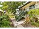 Inviting exterior featuring a staircase leading to the upper-level residence, surrounded by mature landscaping at 1519 Pelican Point Dr # 292, Sarasota, FL 34231