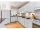 Charming kitchen featuring white cabinets, granite counters, and modern appliances at 1519 Pelican Point Dr # 292, Sarasota, FL 34231