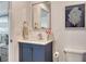 A charming bathroom features a navy vanity with a white countertop, a square mirror and decor at 2155 Harbourside Dr # 804, Longboat Key, FL 34228