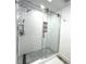 Updated shower with pebble floor, glass door, and decorative textured tile detail at 2155 Harbourside Dr # 804, Longboat Key, FL 34228
