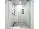 Updated shower with pebble floor, glass door, and decorative textured tile detail at 2155 Harbourside Dr # 804, Longboat Key, FL 34228
