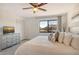 A bright bedroom offers a large window, a ceiling fan, a tv on a dresser, and plush pillows at 2155 Harbourside Dr # 804, Longboat Key, FL 34228