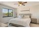 A comfortable bedroom boasts a large window with natural light, a ceiling fan and neutral decor at 2155 Harbourside Dr # 804, Longboat Key, FL 34228