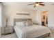 A cozy bedroom includes a ceiling fan, a large window and neutral décor, plus a view of the ensuite at 2155 Harbourside Dr # 804, Longboat Key, FL 34228