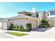 View of the home's front exterior with a two-car garage, a well-manicured lawn, and a nicely paved driveway at 2155 Harbourside Dr # 804, Longboat Key, FL 34228