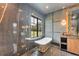 Modern bathroom features a luxurious soaking tub, marble tile, and a stylish vanity at 2410 Slough Rd, Sarasota, FL 34240