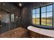 Luxury bathroom boasting a soaking tub, walk-in shower with black marble style tile at 2410 Slough Rd, Sarasota, FL 34240