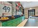 Stylish kitchen boasts green cabinetry, black countertops, and vintage signs, creating a unique design at 2410 Slough Rd, Sarasota, FL 34240